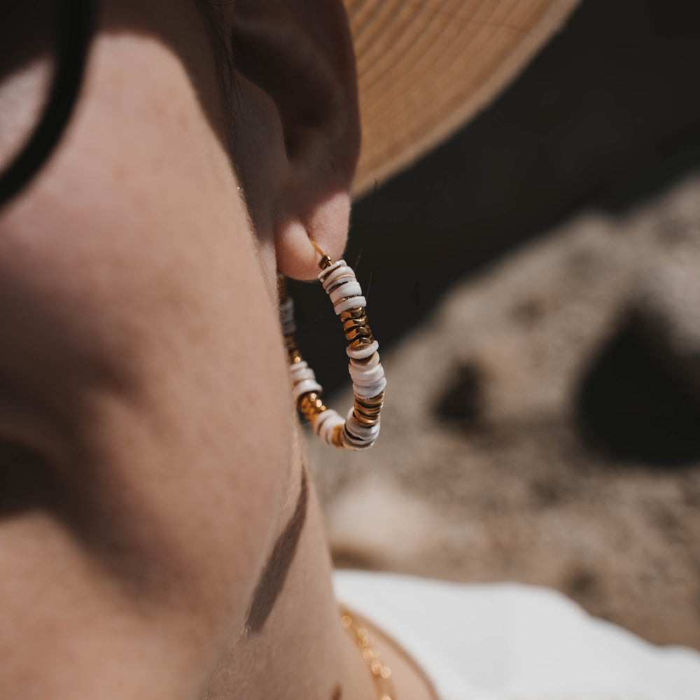 
                      
                        Tossa de Mar | Boucles d'oreilles / créoles en acier inoxydable et pierres naturelles | Coquillage et hématite | Doré
                      
                    