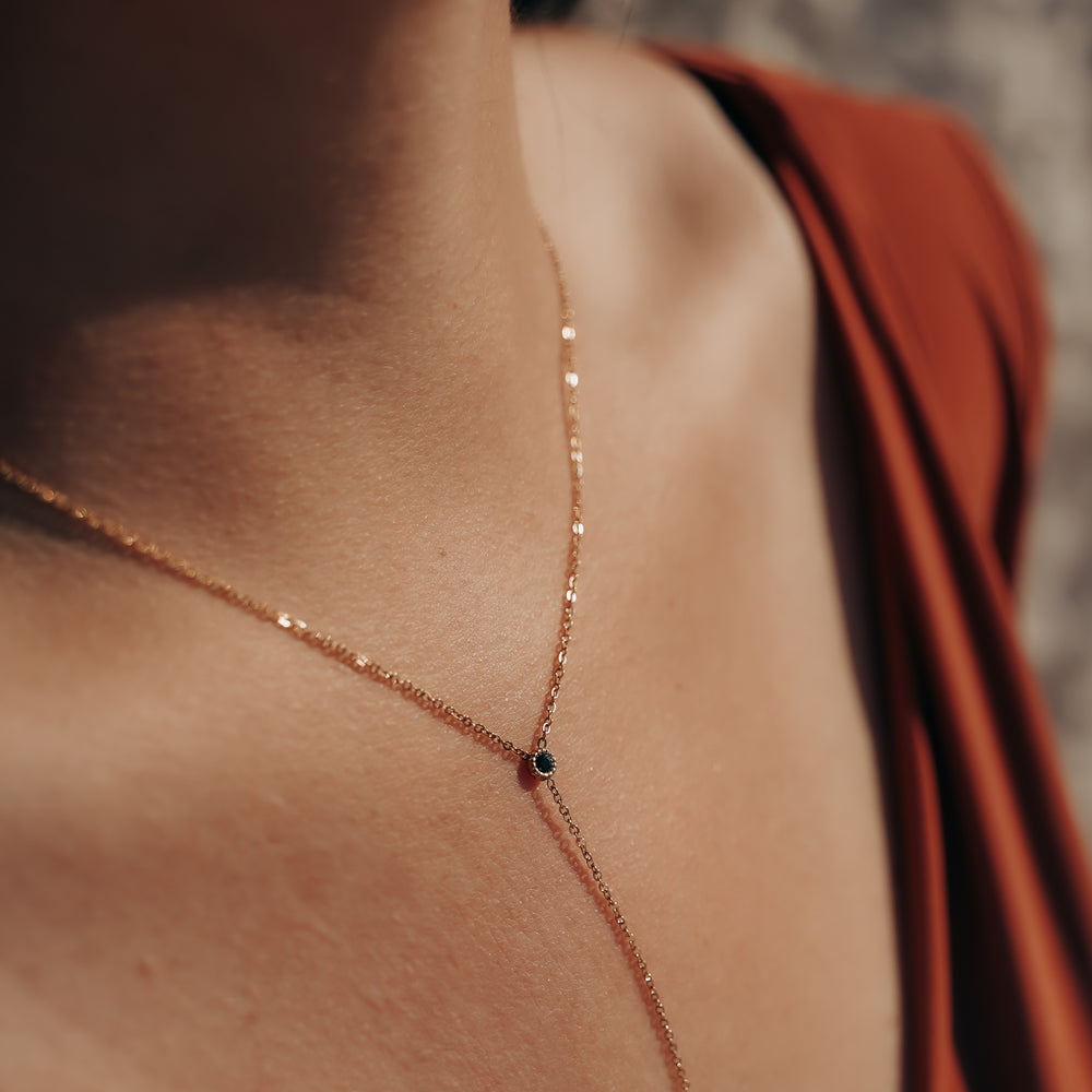 
                      
                        Rhodes | Collier Y en acier inoxydable | Oxyde de zirconium noir | Doré
                      
                    