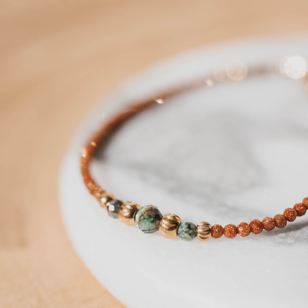 
                      
                        Dakota | Bracelet en acier inoxydable et pierres naturelles | Pierre de sable, turquoise africaine | Doré
                      
                    