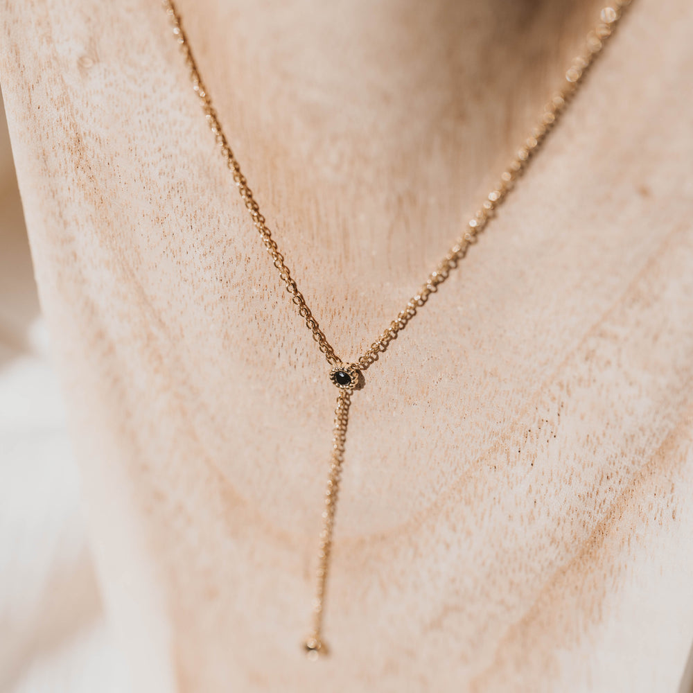 
                      
                        Rhodes | Collier Y en acier inoxydable | Oxyde de zirconium noir | Doré
                      
                    