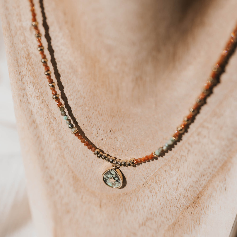 
                      
                        Dakota | Collier en acier inoxydable et pierres naturelles | Pierre de sable et turquoise africaine | Doré
                      
                    